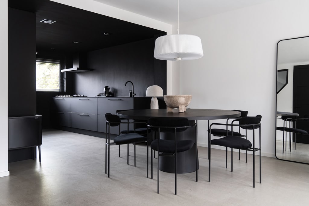 minimalistisch interieur met zwarte ton-sur-ton keuken en zwarte eethoek