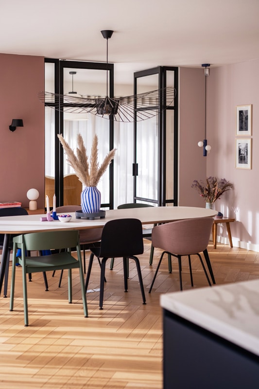 lichte ovale eettafel met kleurrijke scandinavische design stoelen