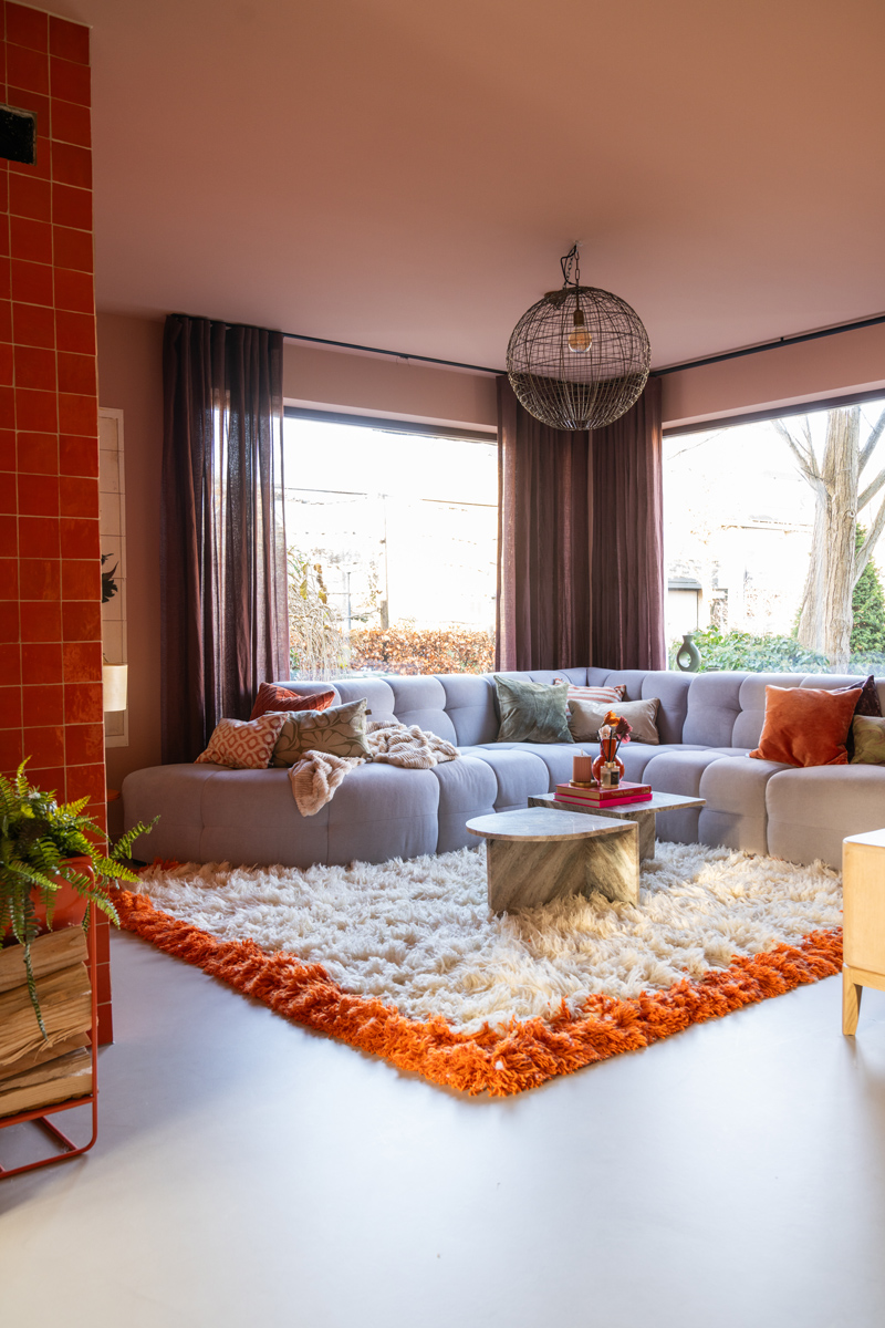 confetti bank zitmaxx hkliving vloerkleed met oranje rand en sombrero tan van histor my color op het plafond en paarse gordijnen van Eijffinger