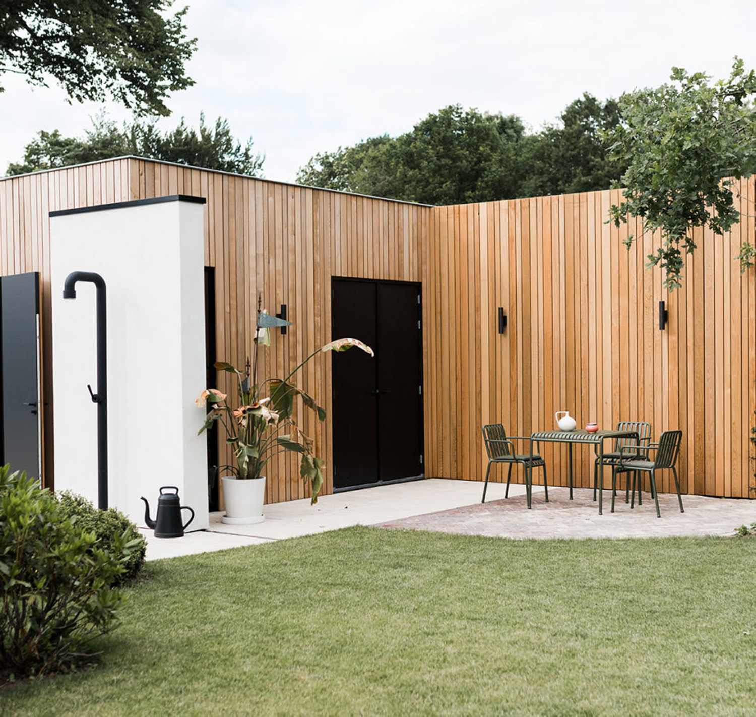 Bed & Breakfast De Lichtboei op de Veluwe - Houten latjes tegen de gevel met groene tuinset van HAY pallisade en zwarte design buitendouche