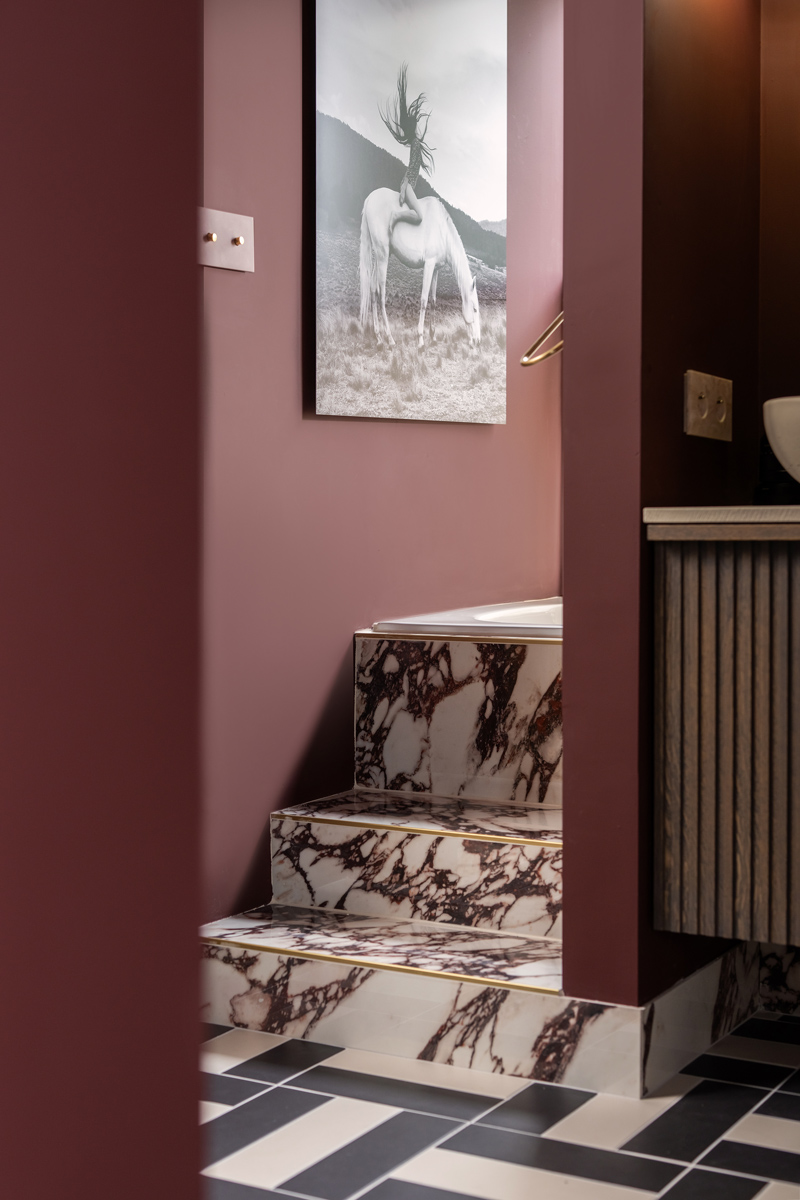 The Home Style Club - Calacatta Viola tegel in het badkamer trapje in de badkamer van Sofie - Merlot Marble badkamercollectie The Home Style Club x Brugman - Badkamer inspiratie met messing en bordeauxrood enchanting eggplant histor