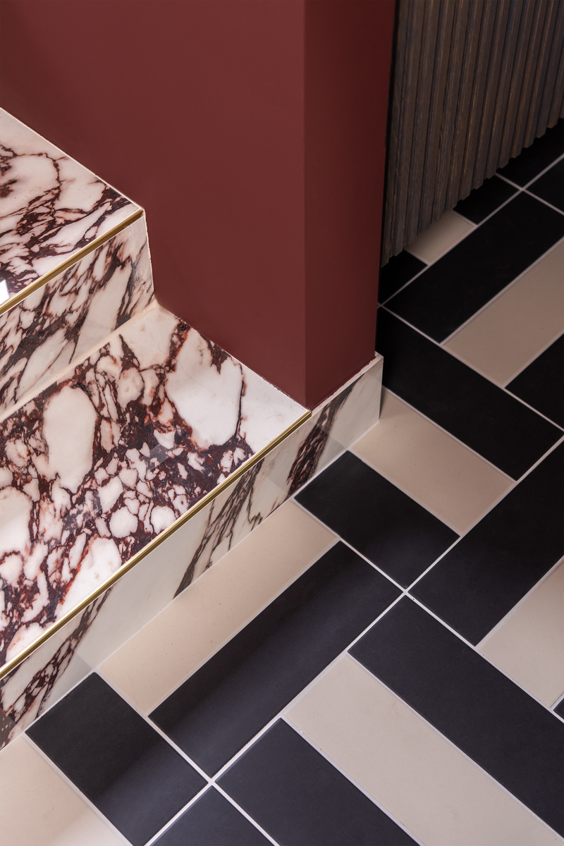 The Home Style Club - Calacatta Viola tegel in het badkamer trapje in de badkamer van Sofie - Merlot Marble badkamercollectie The Home Style Club x Brugman - Badkamer inspiratie met messing en bordeauxrood enchanting eggplant histor