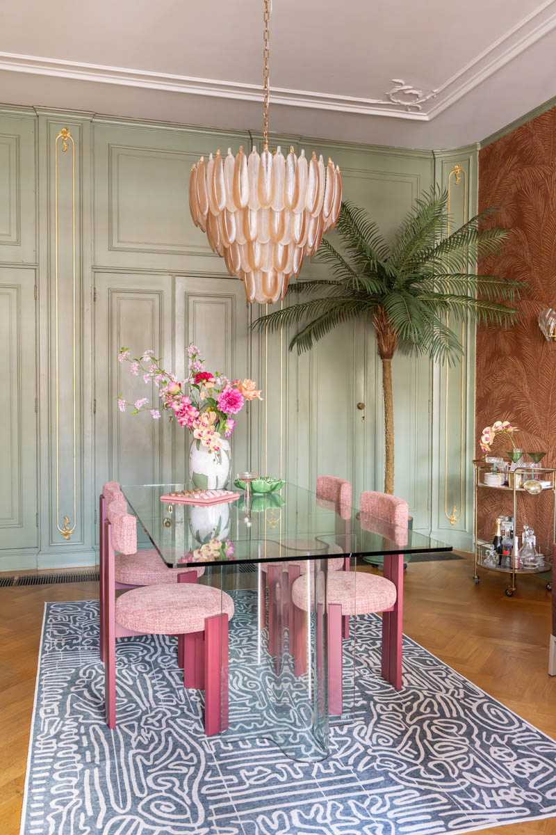 Kantoor met glazen tafel en ingebouwde kastenwand met Keith Herring geïnspireerd vloerkleed van Ruggable