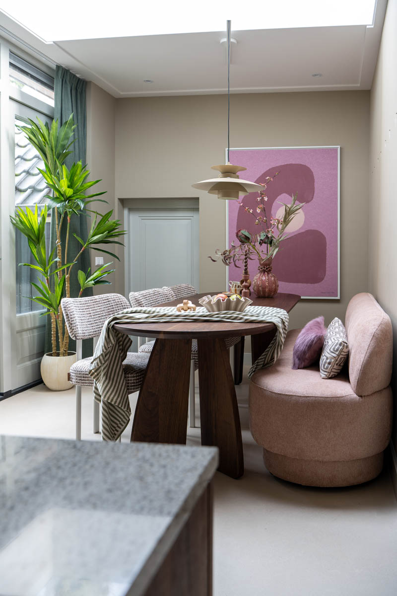 Warme eethoek met kunst aan de muur en zachte materialen